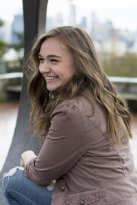 young woman looks over her shoulder smiling at western washington lifestyle portrait photographer adina stiles
