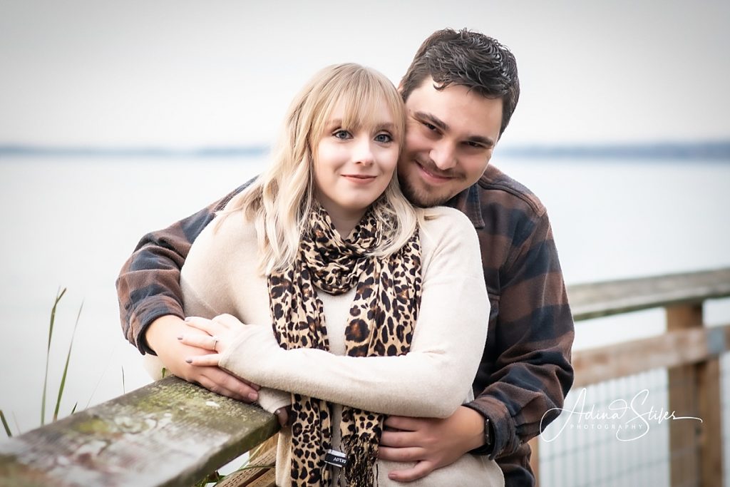 A couple stands on a bridge together for engagement photos in Boulevard Park, Bellingham, Washington.