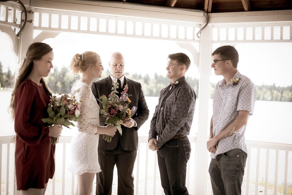 A bride and groom exchange vows under a gazebo during an elopement in Puget Sound. 