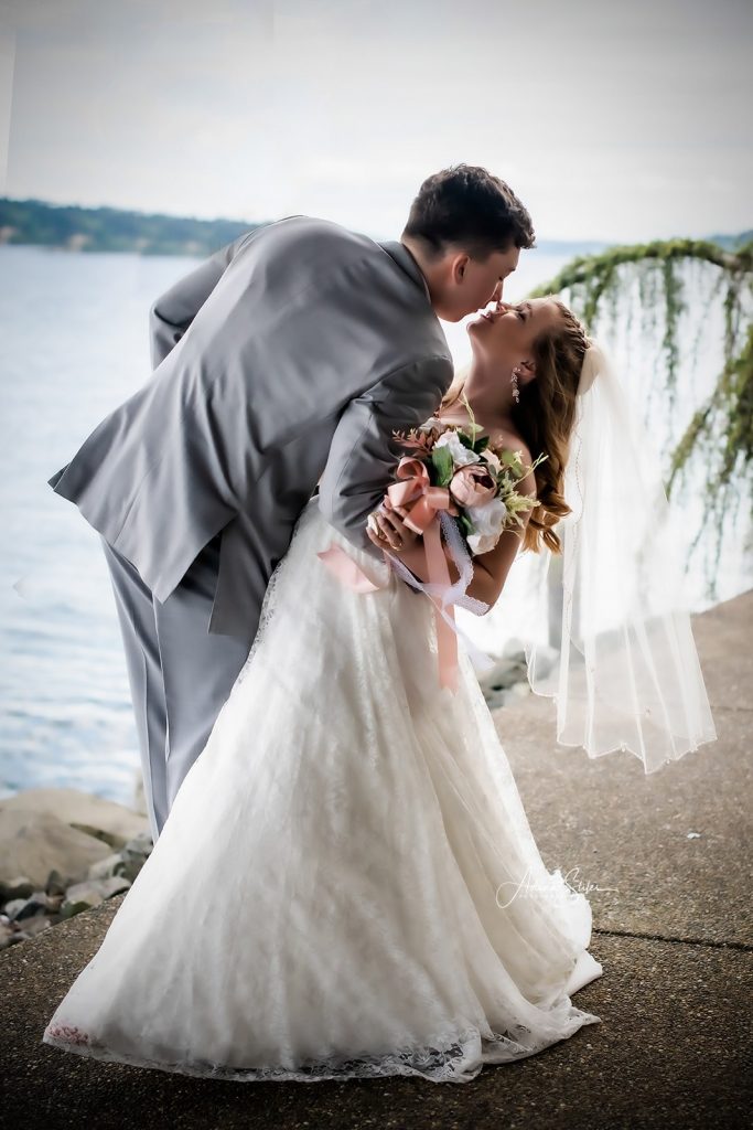 A groom dips his bride by the water during a last-minute wedding celebration in Puget Sound, Washington.